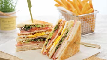 A sandwich cut in half with a toothpick, placed on a wooden board.
