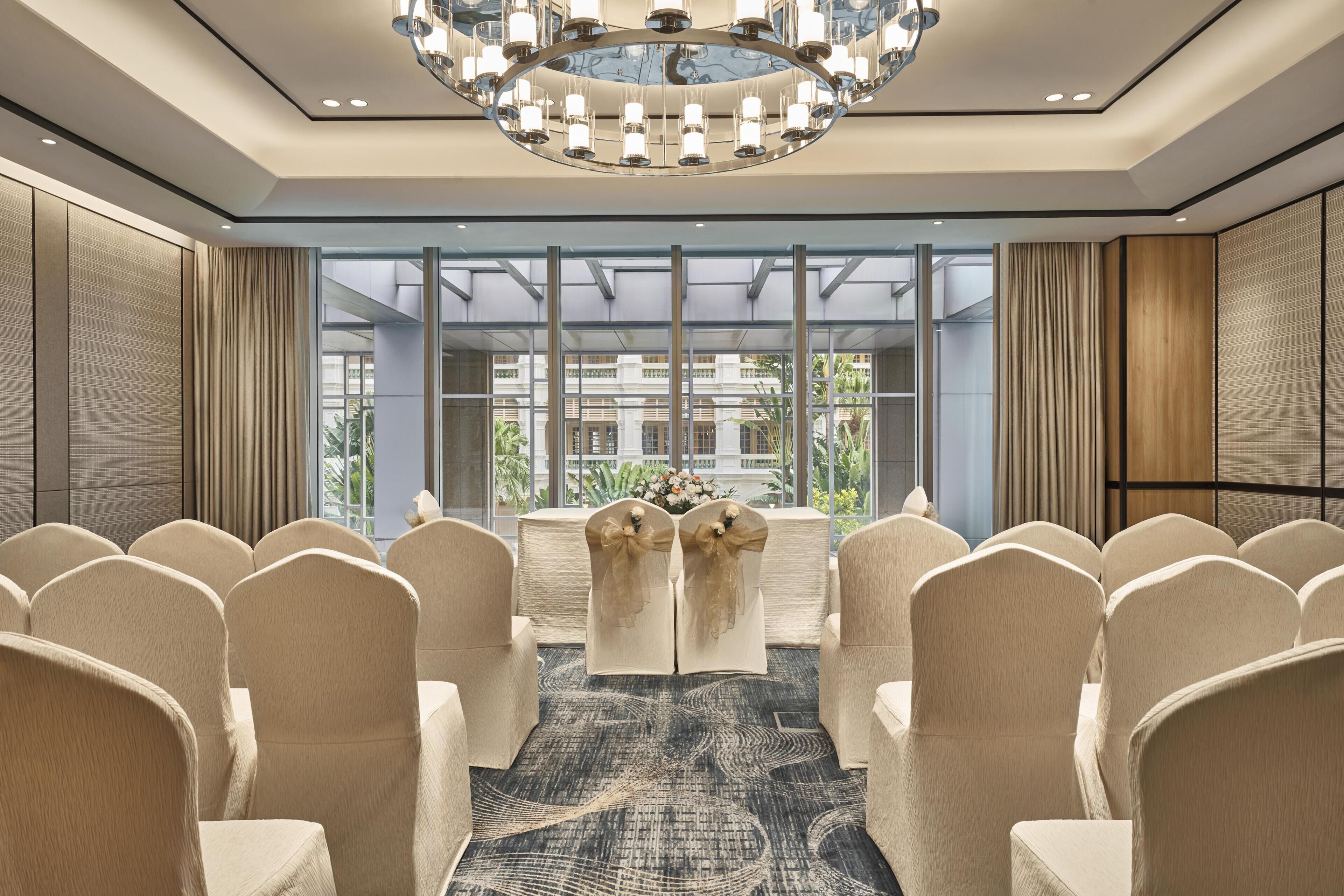 Une salle de conférence équipée d’une grande table, de chaises et d’un lustre.
