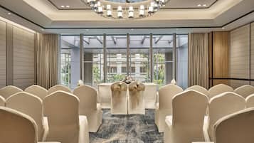 Une salle de conférence équipée d’une grande table, de chaises et d’un lustre.