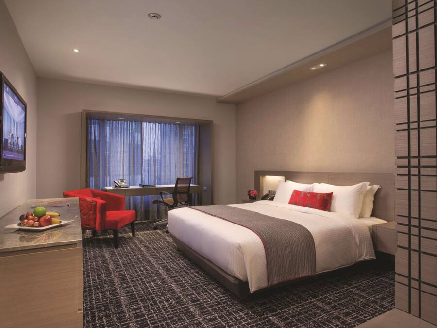 Een hotelkamer met een bed, een bureau, een stoel en een televisie.