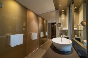 Une salle de bain moderne avec un grand lavabo blanc, une douche en verre et un miroir.