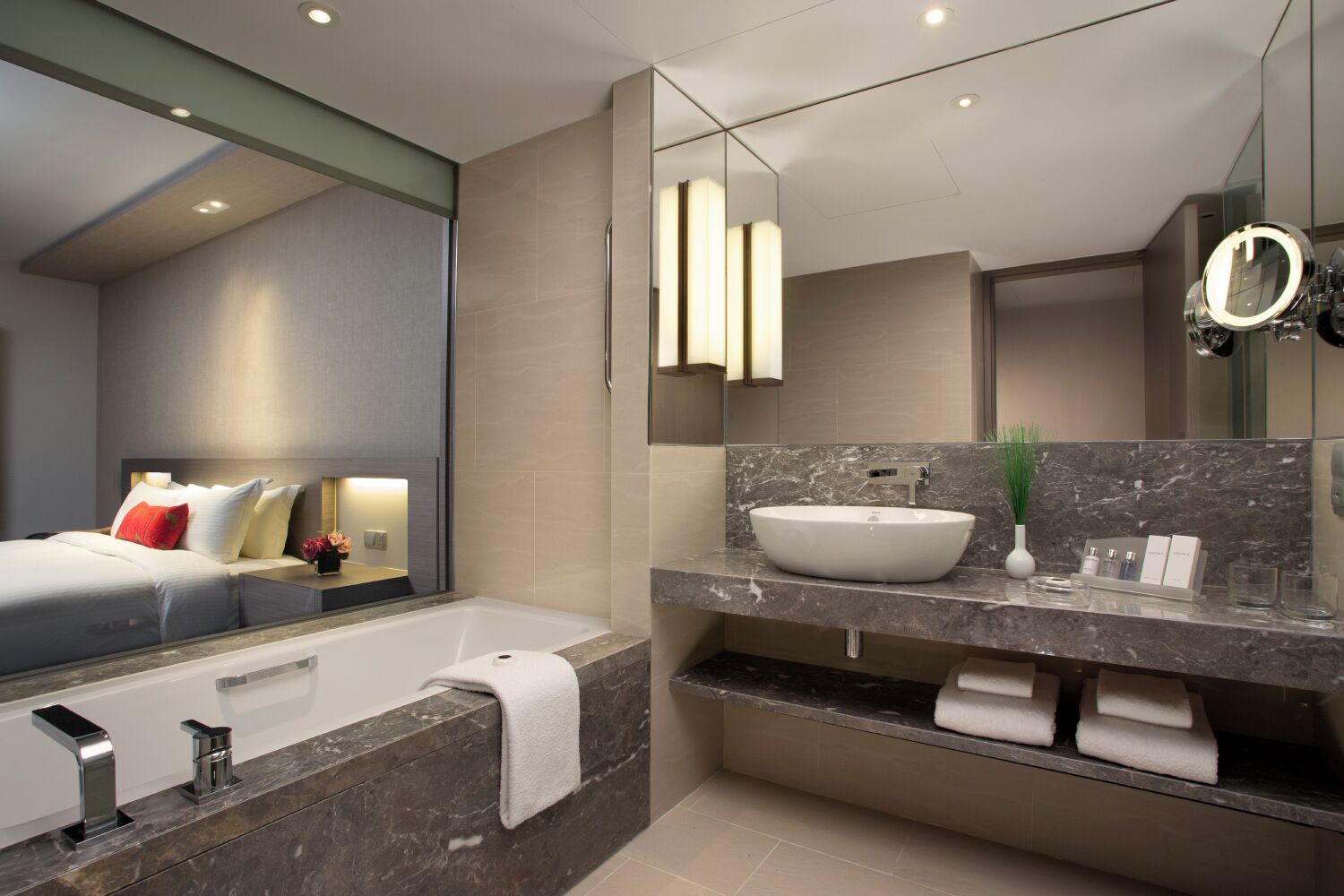 A modern bathroom with a large bathtub, a vanity with a white sink, and a large mirror.
