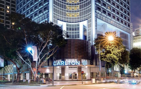 A tall hotel with a curved facade, illuminated signage, and a prominent 'Carlton' sign at the top.