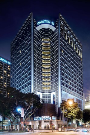 Un grand hôtel à la façade incurvée, doté d’une enseigne lumineuse et d’un grand panneau « Carlton » bien visible sur le dessus.