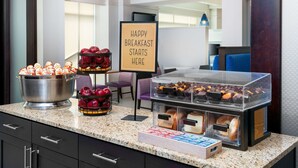 A breakfast buffet with various pastries, fruits, and bread. - Hampton Inn & Suites Buffalo Downtown (Buffalo)