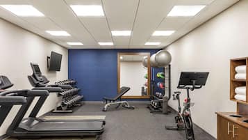 A gym with treadmills, a stationary bike, and a weight bench.