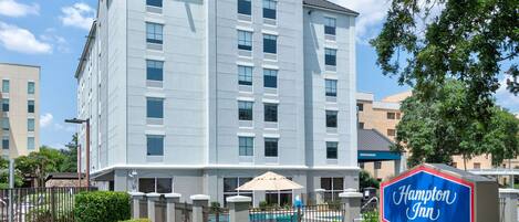 A Hampton Inn by Hilton building with a pool area in front.