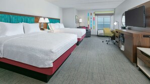 A hotel room with two beds, a desk, a TV, and a large window. - Hampton Inn Biloxi (Biloxi)