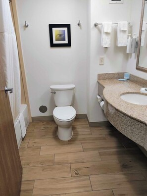 A bathroom with a toilet, a sink, and a mirror.