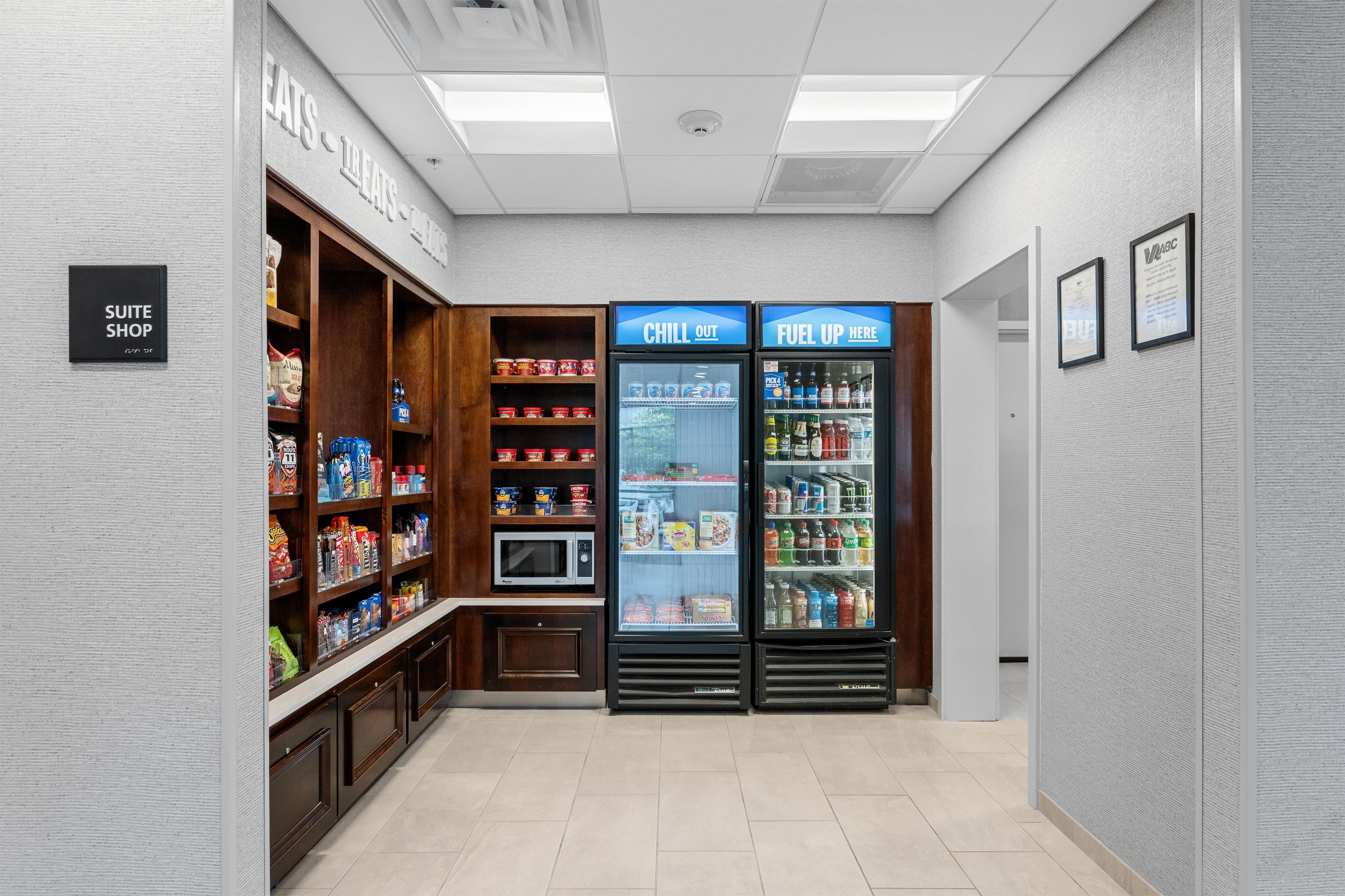 A kitchenette area with a microwave, a coffee machine, and a refrigerator stocked with beverages.