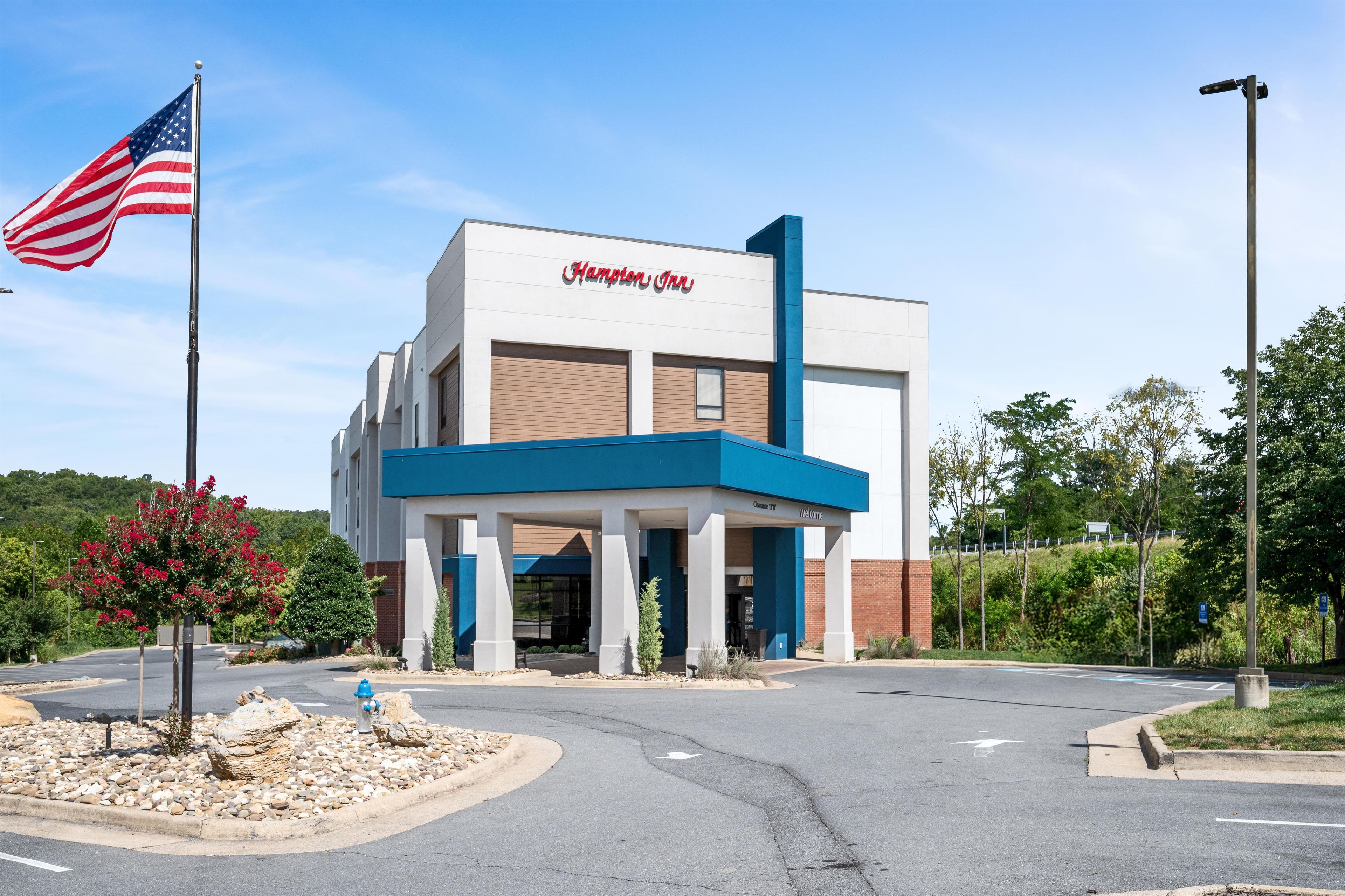 A Hampton Inn hotel with a modern facade, a clear entrance, and a parking lot.