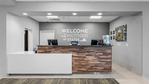 A reception desk with a "Welcome to the Mother of States" sign, a Hilton Honors logo, and a cityscape artwork on the wall. - Hampton Inn Front Royal (Front Royal)