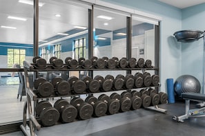 A gym with weightlifting equipment, including dumbbells and a bench. - Hampton Inn Front Royal (Front Royal)