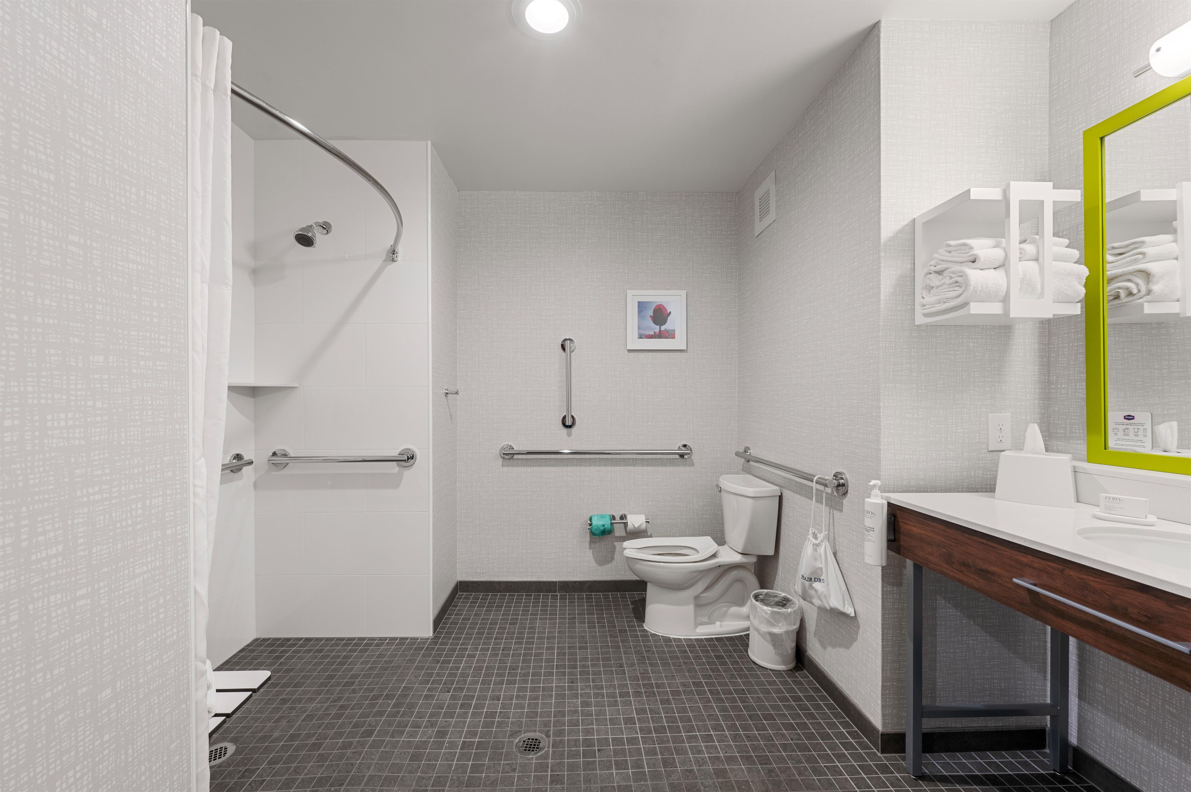 A modern bathroom with a shower, toilet, and sink.