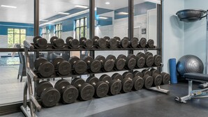 A gym with weightlifting equipment, including dumbbells and a bench. - Hampton Inn Front Royal (Front Royal)