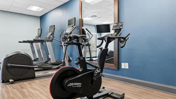 Ein Fitnessstudio mit Ergometer, Laufband und Rudergerät.
