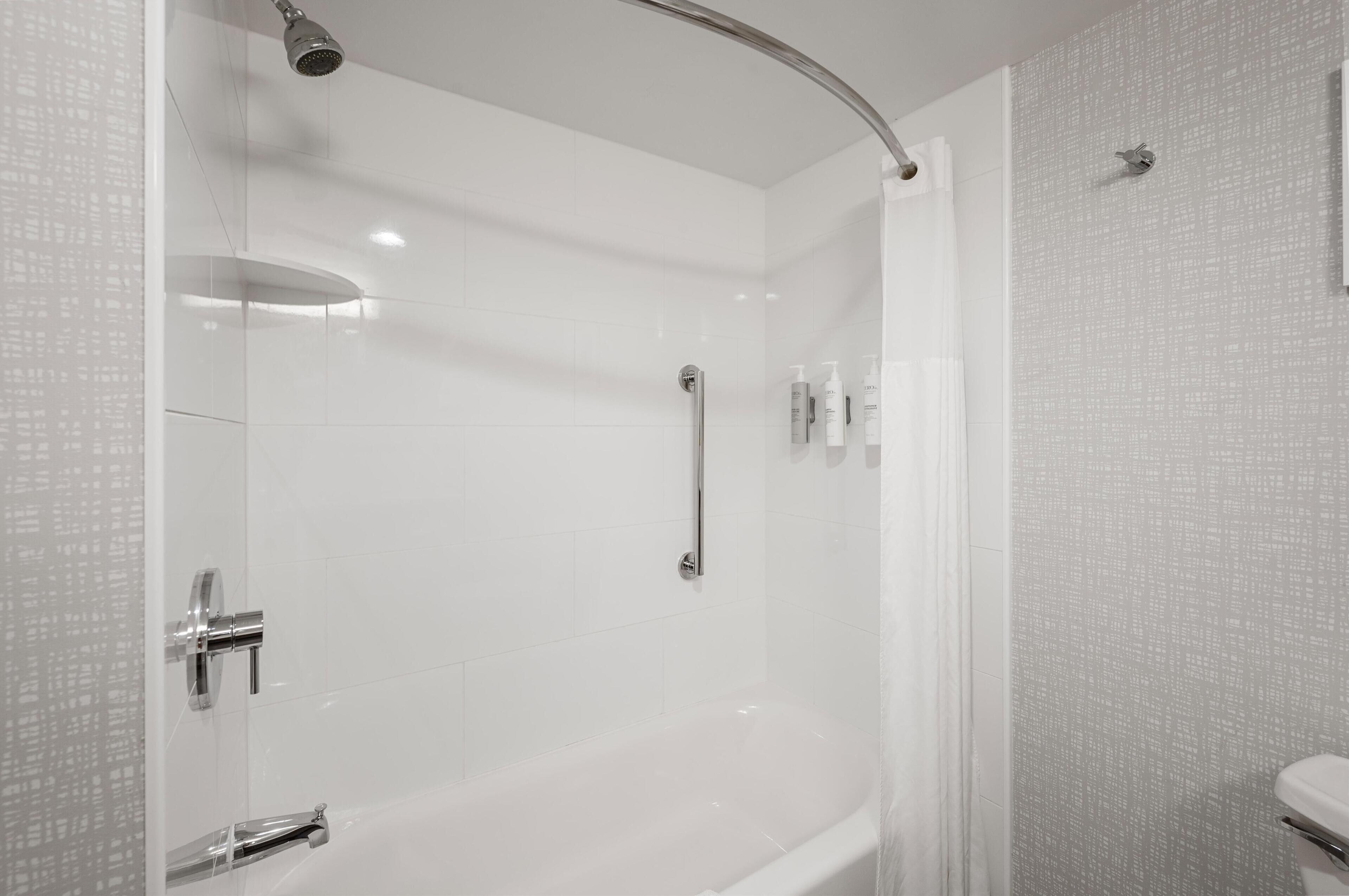 A modern bathroom with a glass-enclosed shower, a standalone bathtub, and a toilet.