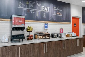 A kitchen area with a juice station, a bakery sign, and a kitchen sign.