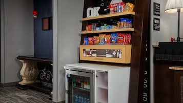 Una máquina expendedora con aperitivos y un refrigerador.