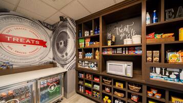 A snack and treat section with refrigerated drinks, microwaves, and various snack items.