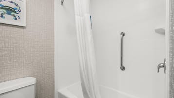 Un baño con una bañera blanca, una cortina de ducha, un asidero y un cuadro en la pared.