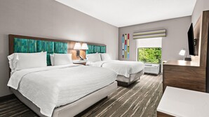 A hotel room with two beds, a desk, a chair, a TV, and a window with a view of greenery. - Hampton Inn Elkton (Elkton)