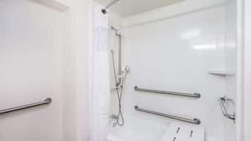 A modern bathroom with a walk-in shower, grab bars, and a bathtub.