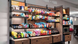 A snack display with various packaged foods and a microwave. - Hampton Inn Chicopee/Springfield (Chicopee)