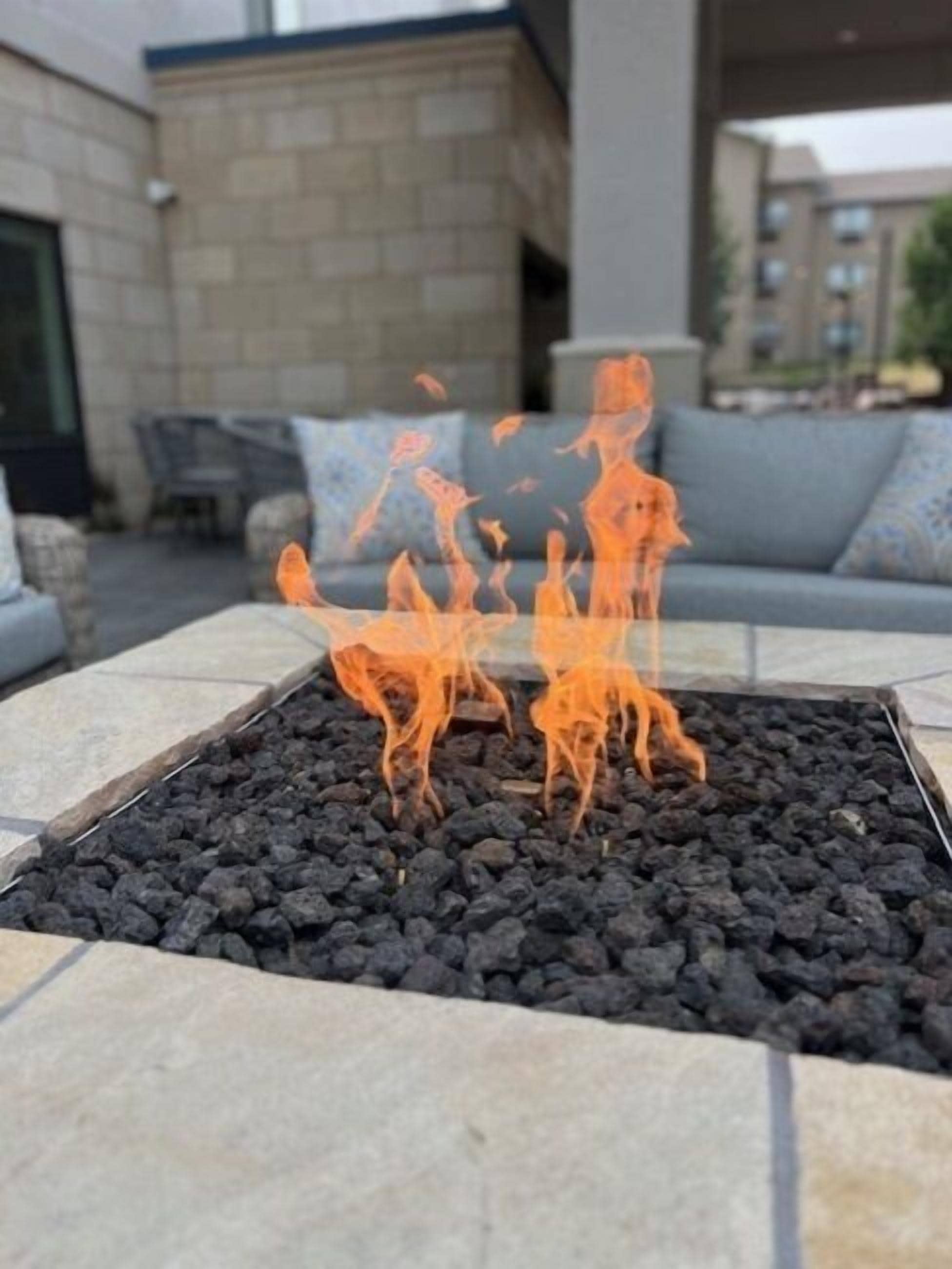 Un foyer extérieur, entouré de pierres, où brûle un feu.