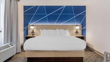 A hotel room with a large bed, two bedside tables with lamps, a wall with a geometric pattern, and a window with curtains.