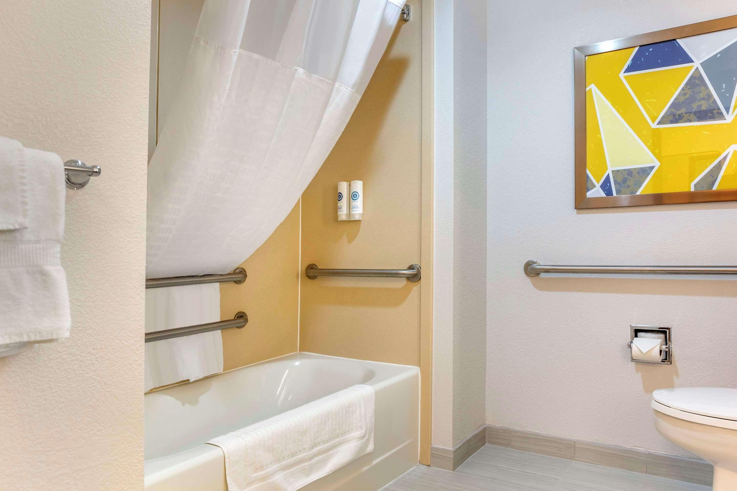 Une salle de bain avec une baignoire, des toilettes et un rideau de douche.