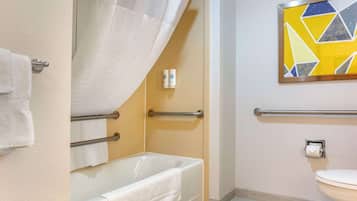 Une salle de bain avec une baignoire, des toilettes et un rideau de douche.