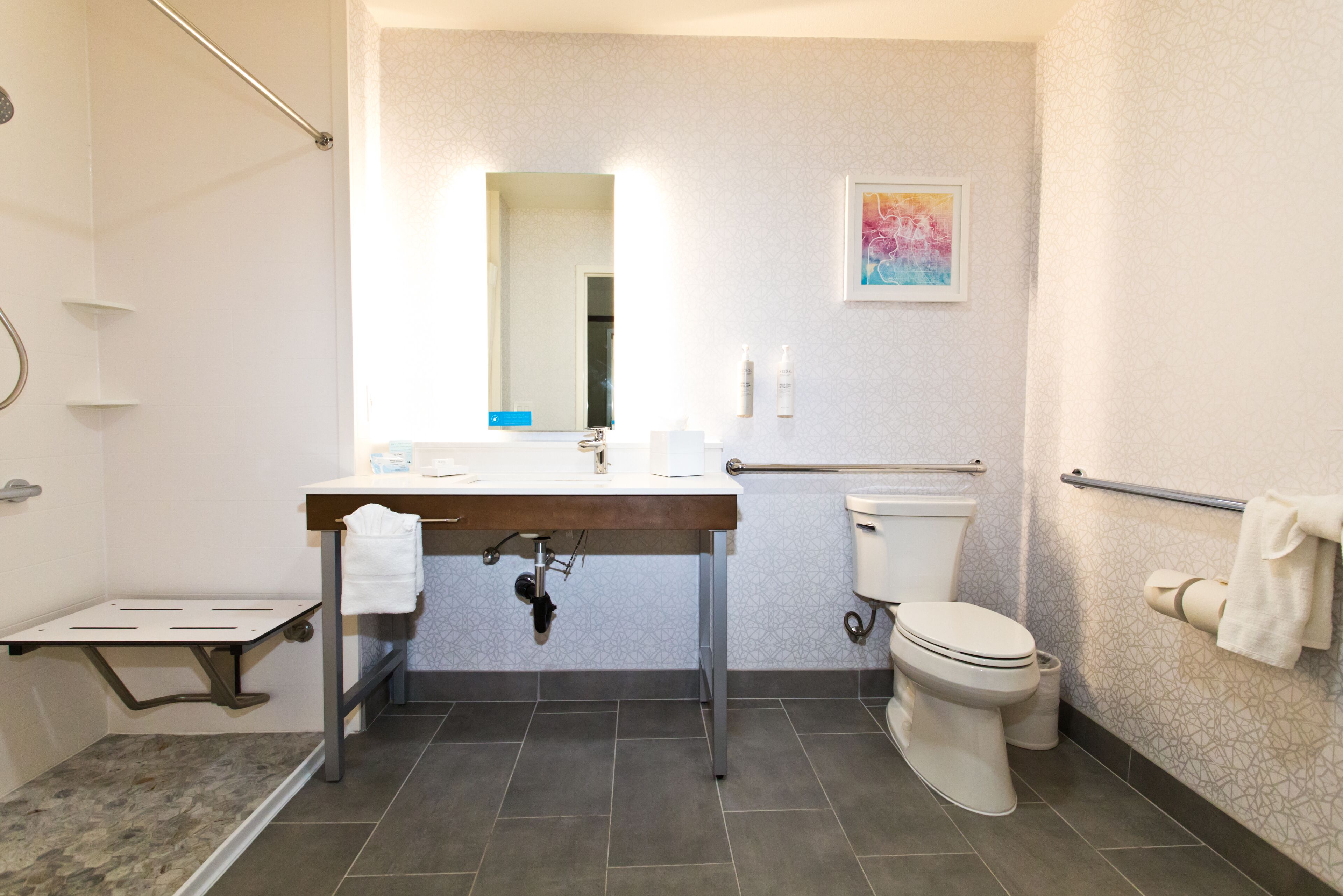 A modern bathroom with a shower, toilet, and sink.
