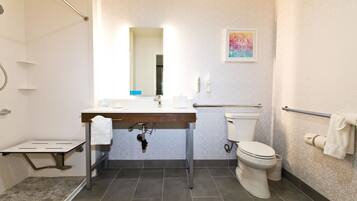 A modern bathroom with a shower, toilet, and sink.