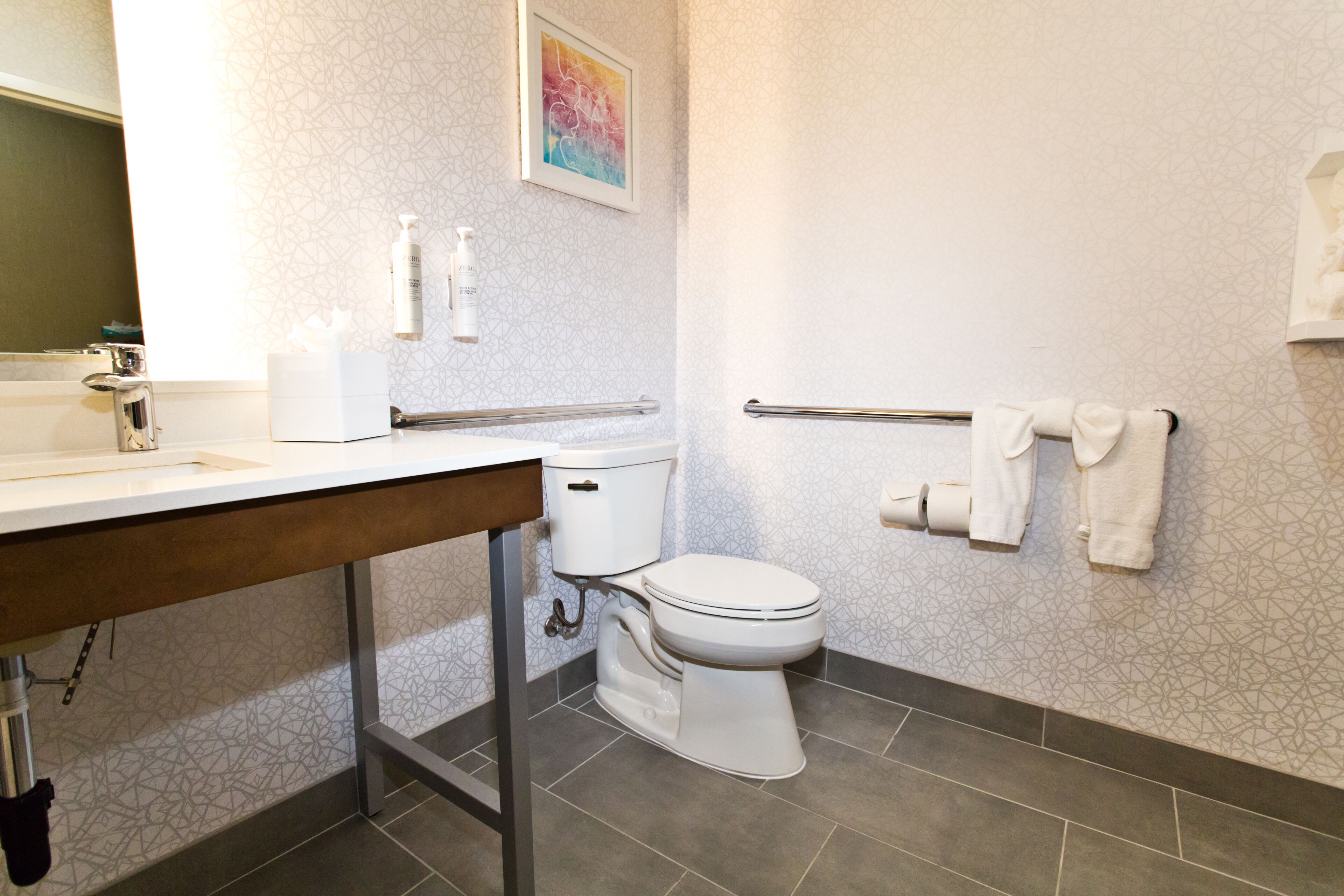 Et moderne badeværelse med toilet, håndvask og håndklædestige.