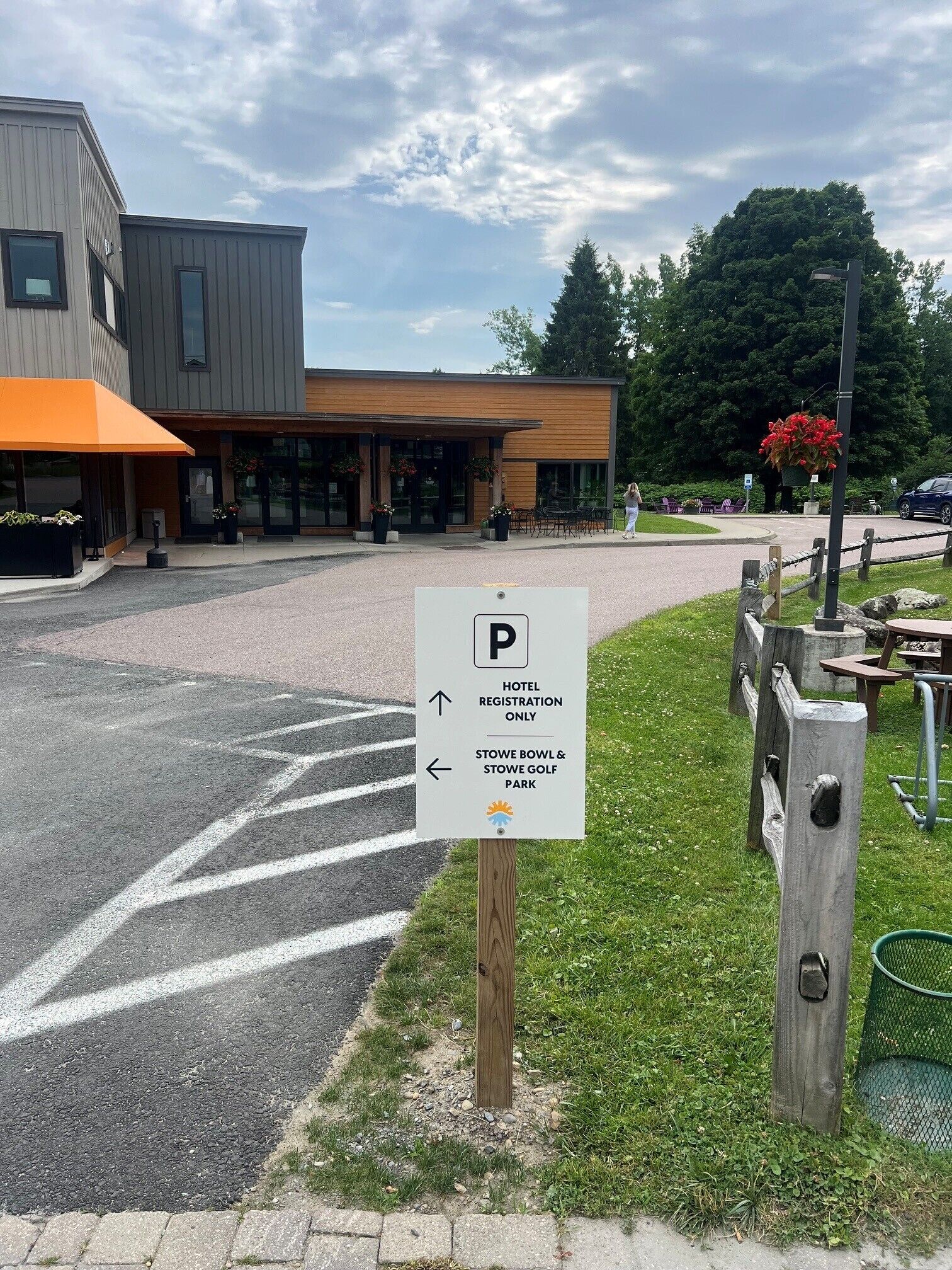 A hotel entrance with a parking sign indicating directions to the hotel registration and the stowe bowl & golf park.