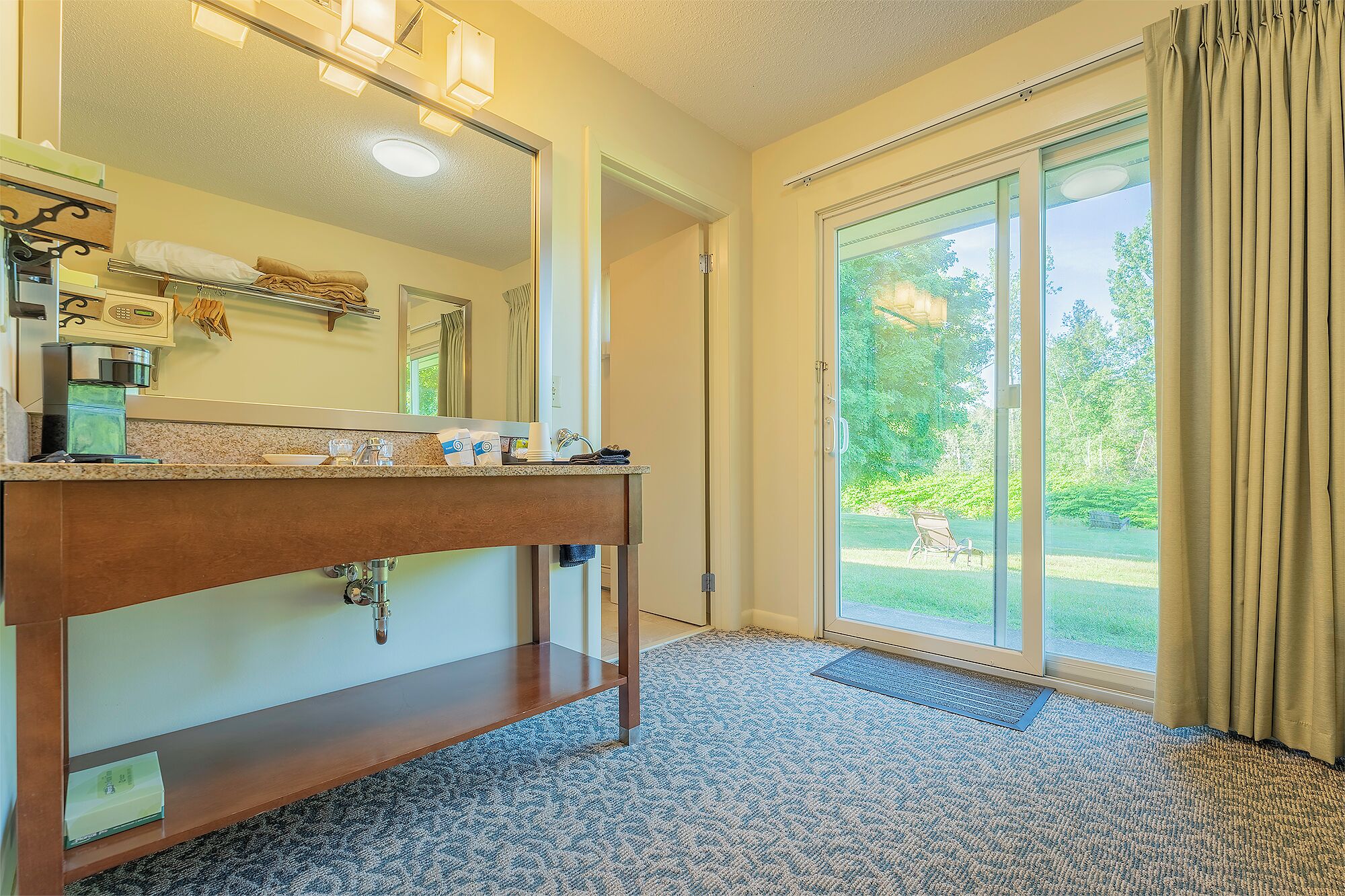 A bathroom with a large mirror, a vanity with a sink, and a shower area.