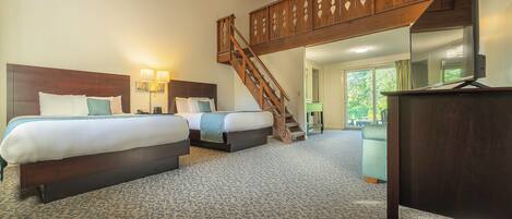 A hotel room with two beds, a wooden staircase, a desk, and a large window.