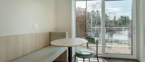 A modern room with a bench, a round table, and two chairs.