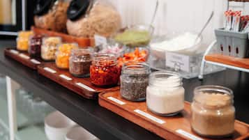 Una variedad de alimentos expuestos en una bandeja de madera, incluyendo frascos de especias, salsas y aderezos.