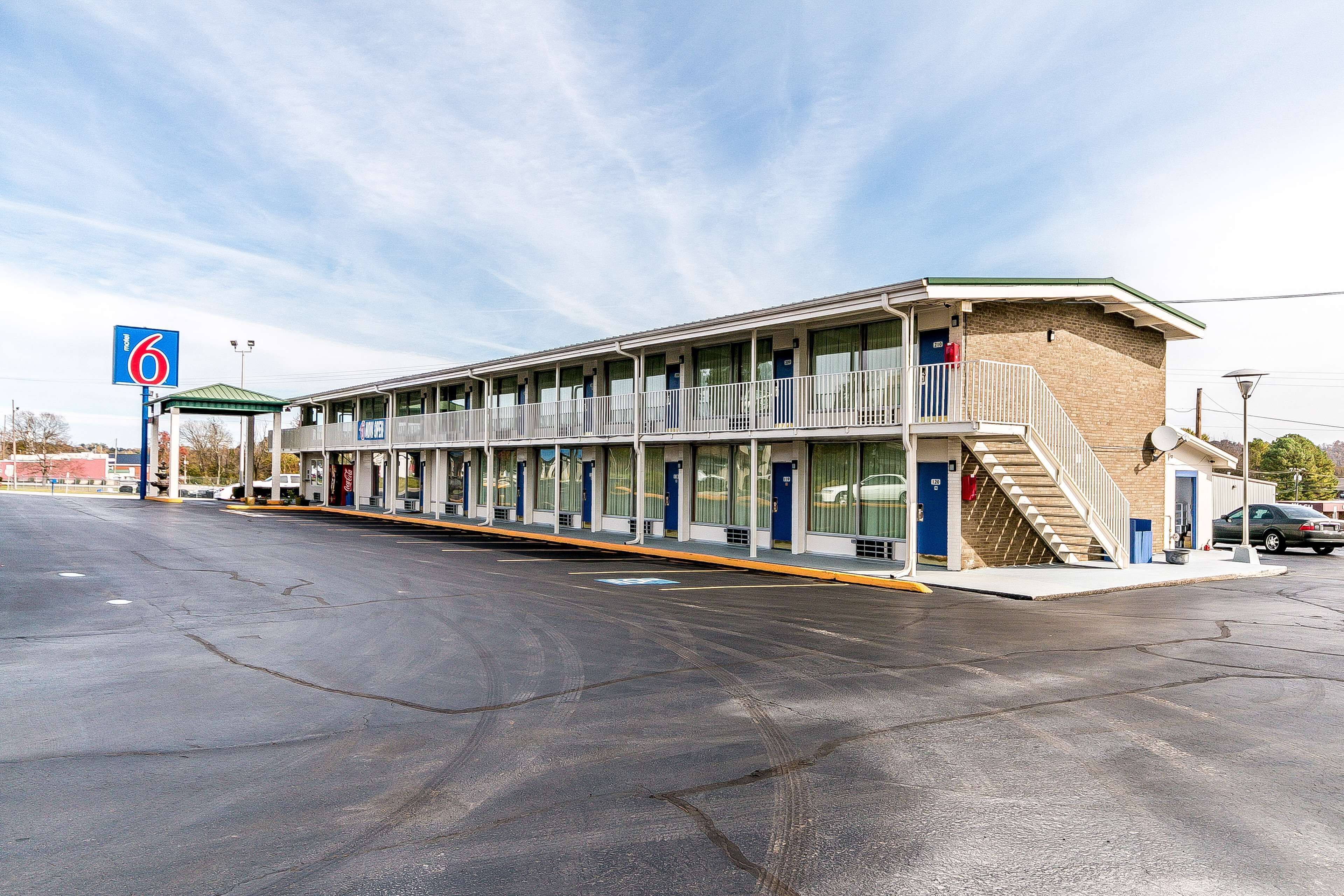 A motel with a central corridor, individual rooms on either side, and a parking lot.