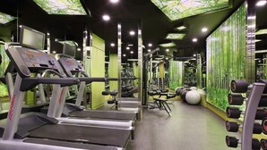 A gym with treadmills, weight machines, and a mirrored wall. - Village Hotel Albert Court by Far East Hospitality (Singapore)