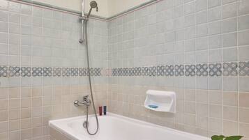 A bathroom with a bathtub, a toilet, and a shower.