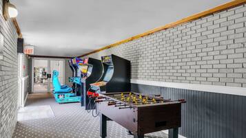 Relax and unwind in this cozy space, featuring a foosball table and gaming machine for entertainment.