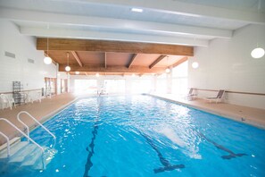 Una piscina techada, sillones reclinables de piscina