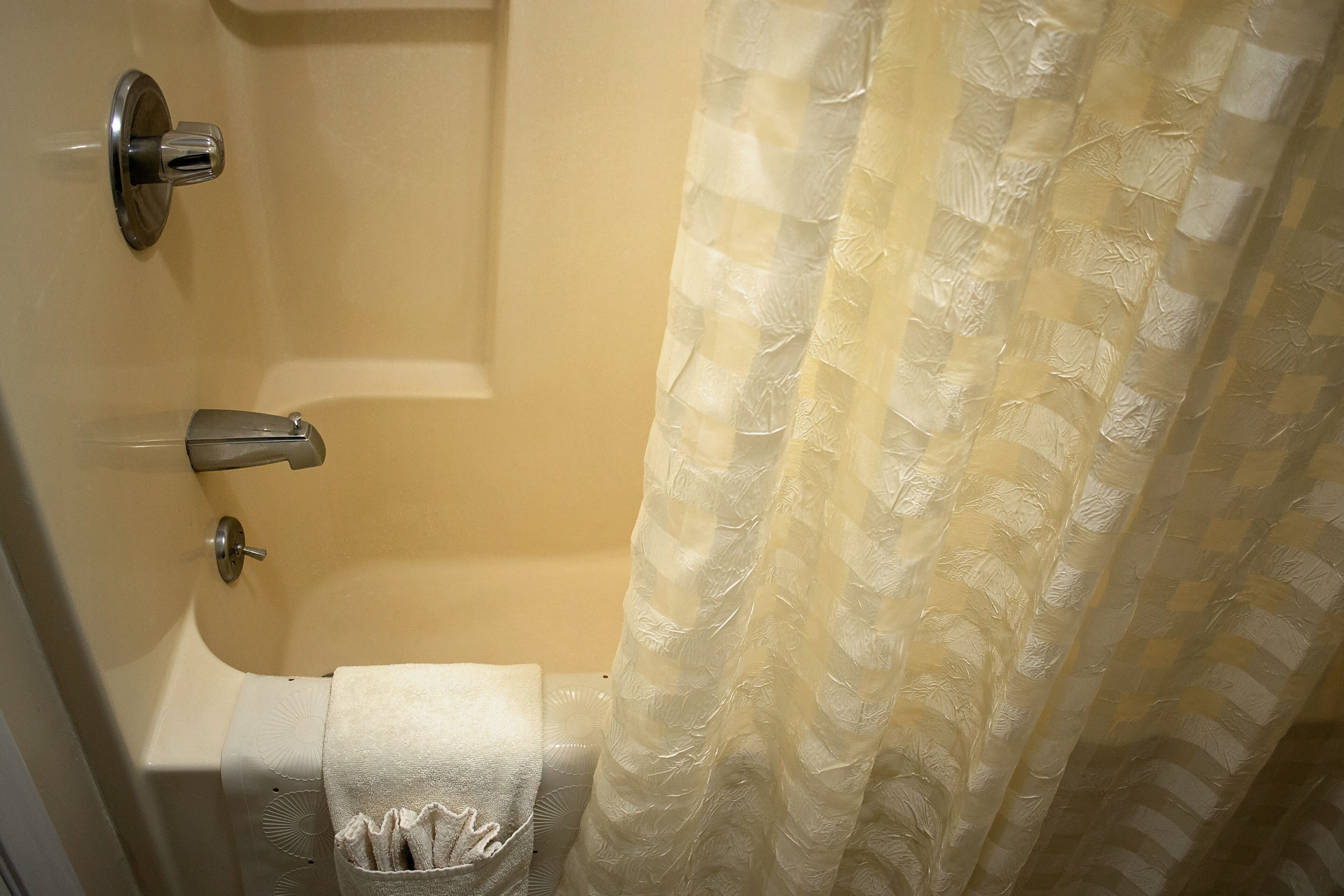 A bathroom with a bathtub, a toilet, and a shower curtain.