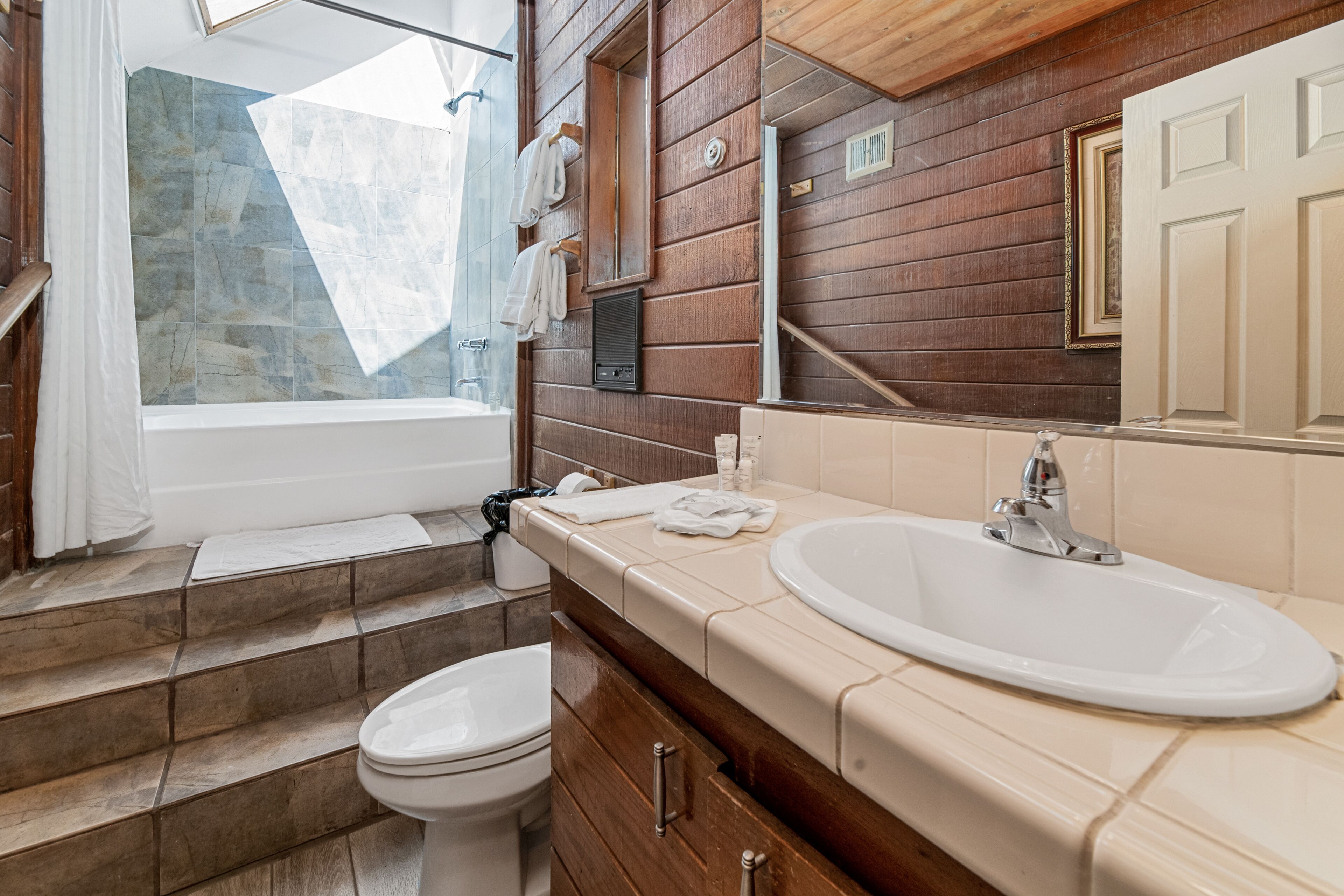 Een badkamer met een bad, toilet en wastafel.