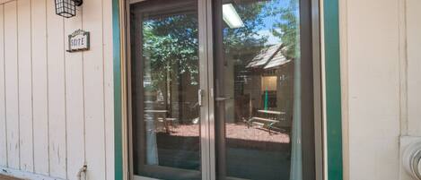 A wooden exterior with a sliding glass door and a welcome sign.