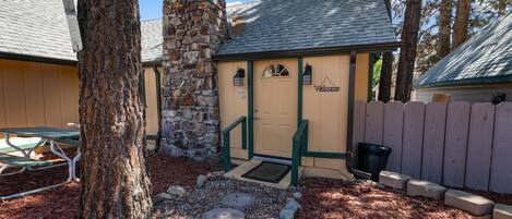 A building with a stone facade, a wooden door, and a 'Welcome' sign.