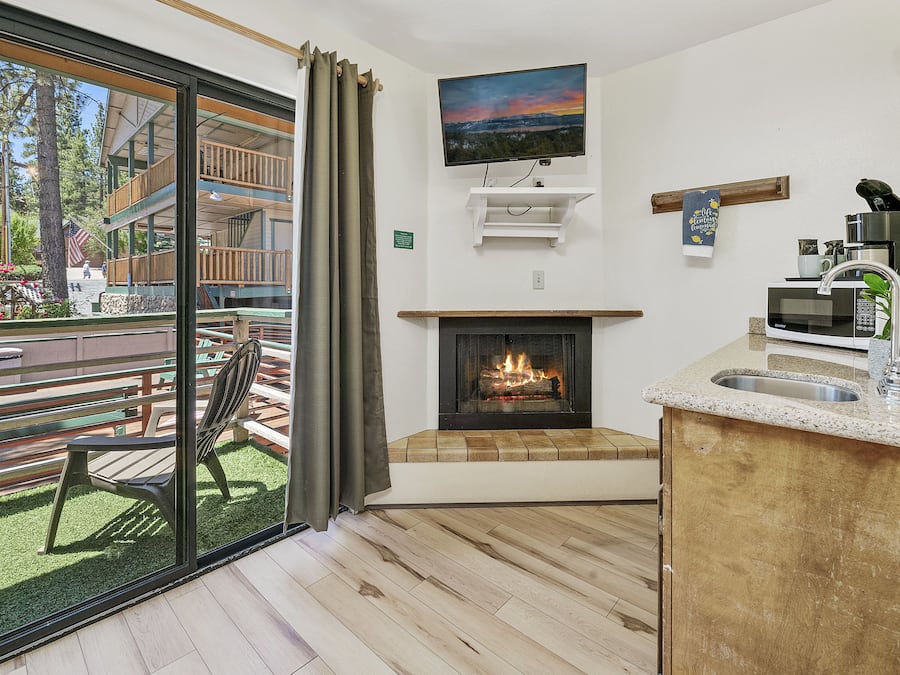 Eine moderne Küche mit Kamin, Flachbildfernseher und Essbereich mit einer Bank und einem Tisch.